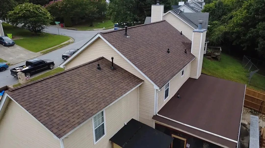 The same home with new reddish-brown architectural shingles on every slope.