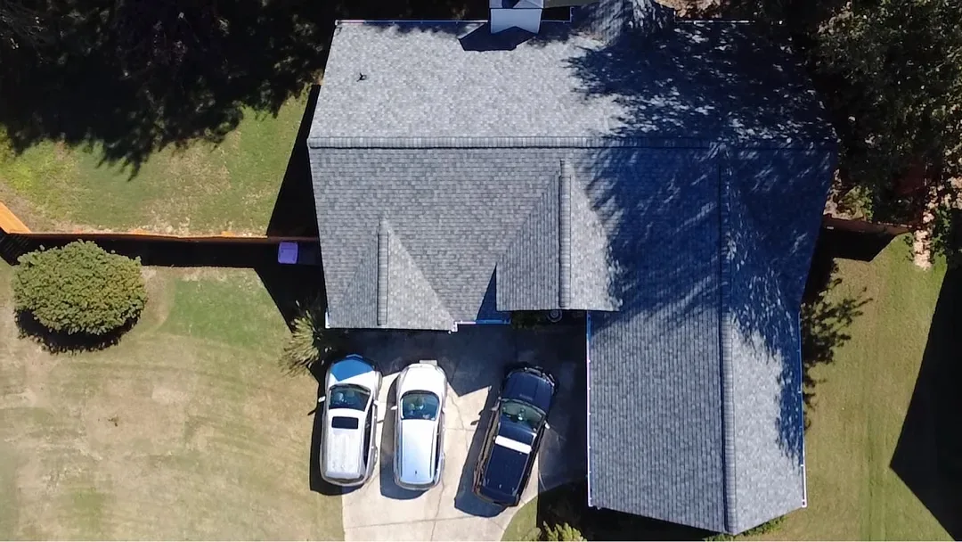 The same home from above with a new gray architectural shingle roof on every slope.